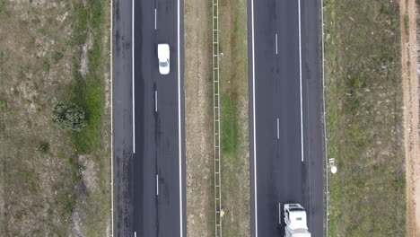 Fix-aerial-shot-above-a-highway-with-cars-passing-low-altitude